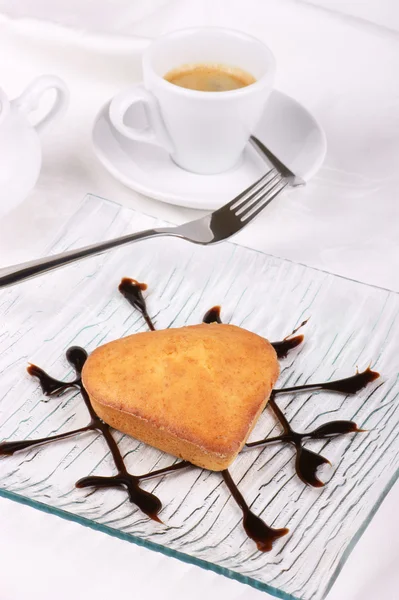 Mały tort w kształcie serca przy filiżance kawy — Zdjęcie stockowe