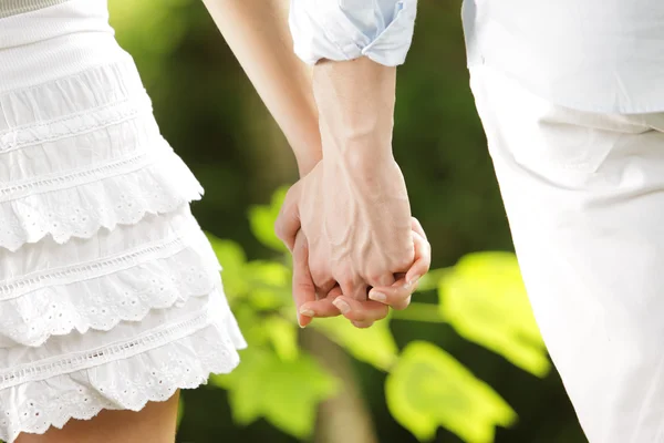Holding hands in a park — Stock Photo, Image
