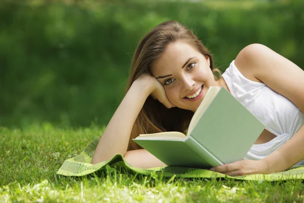 Smilende kvinde læser bog - Stock-foto