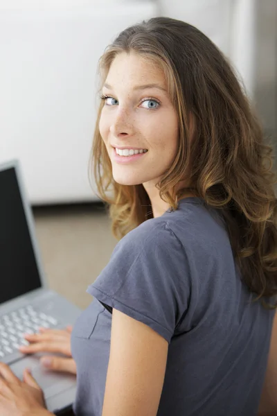 Sweet young lady on couch with laptop — Stock Photo, Image