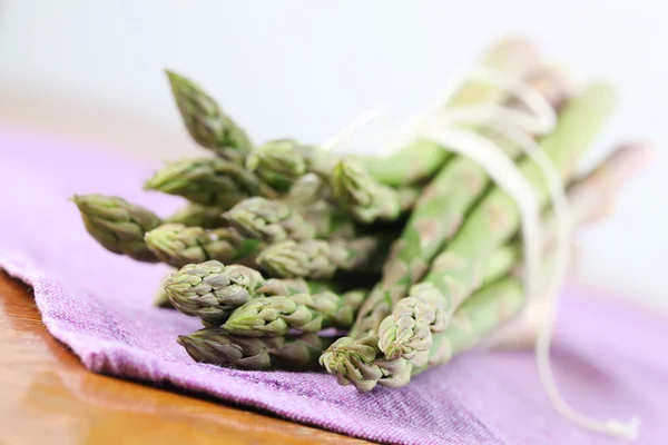 Groene asperges op paarse servet — Stockfoto