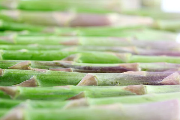 Groene asperges vloeien voort achtergrond — Stockfoto