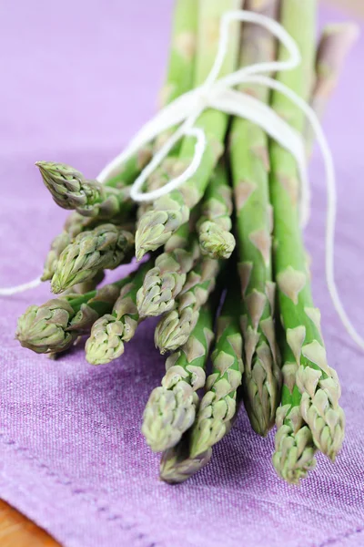 Green asparagus on purple napkin — Stock Photo, Image