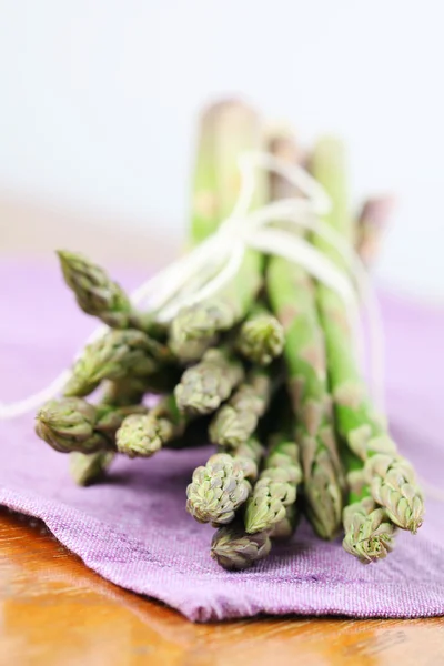 Zielone szparagi na fioletowy serwetki — Zdjęcie stockowe