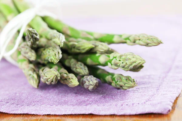 Green asparagus on purple napkin — Stock Photo, Image