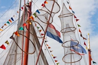 Fishing ship decorated with nets and flags from holland and fish clipart