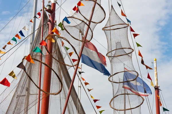Rybářské lodi zdobí sítí a vlajky z Holandska a ryb — Stock fotografie