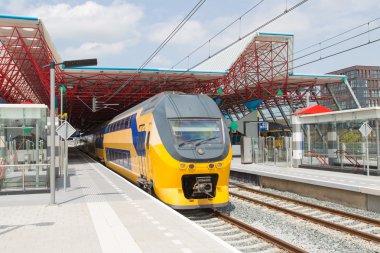 A train is leaving the central station of Lelystad, the Netherla clipart