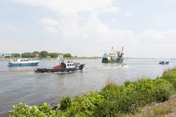 Des bateaux de pêche décorés quittent un port — Photo