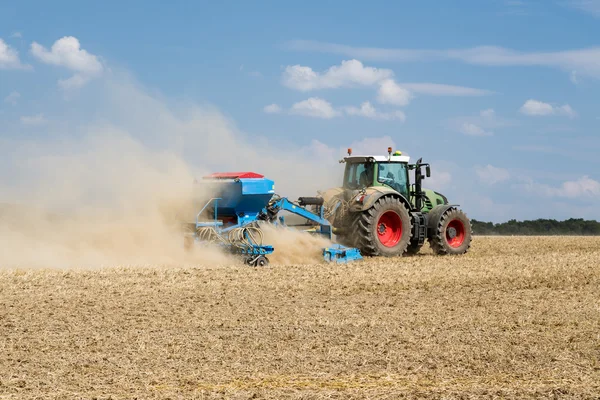 Trator com uma máquina de semeadura trabalhando no campo — Fotografia de Stock