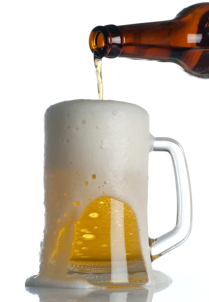 Piwo jest zalewanie kubek na białym tle — Zdjęcie stockowe