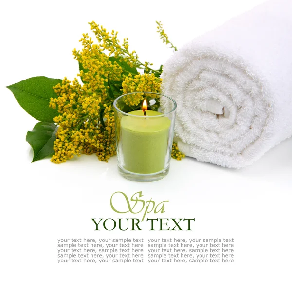 Ajuste de spa con toalla enrollada, flores y vela encendida — Foto de Stock