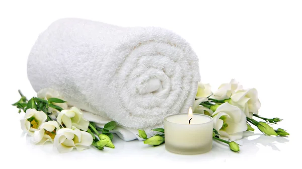 Weiß gerolltes Handtuch mit Blumen und Kerzenschein — Stockfoto