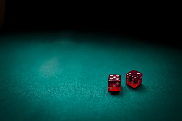 Dois dados vermelhos em uma mesa de cartão — Fotografia de Stock