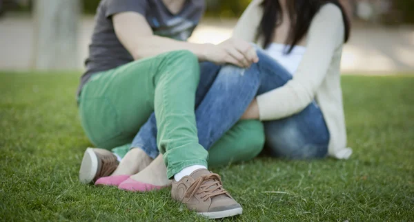 Молодая пара сидела на траве — стоковое фото