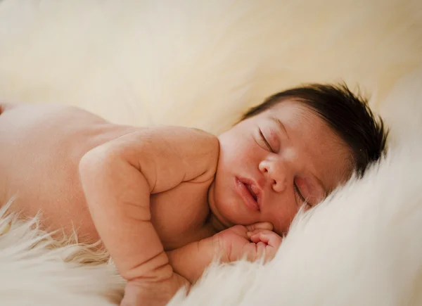 Novorozenec spí na bílý koberec — Stock fotografie