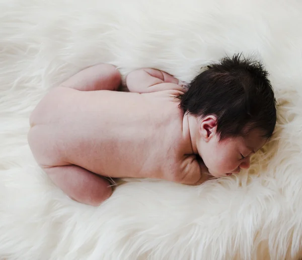 Bébé nouveau-né nu sur un tapis blanc — Photo