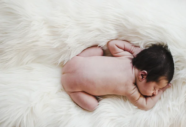 Newborn naked on a white blanket with copy space — Stock Photo, Image