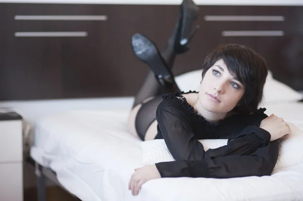 Seksi kız uzağa bakarak yatakta yatıyordu — Stok fotoğraf
