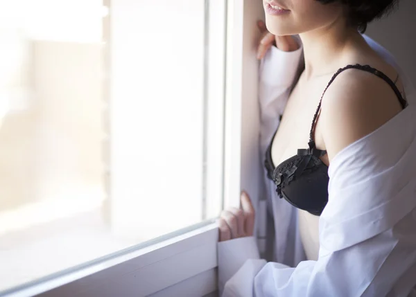Söt flicka med ingen ansikte titta på fönstret i underkläder — Stockfoto