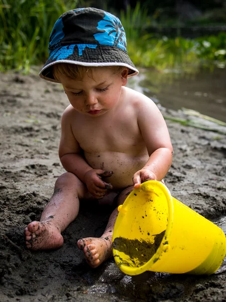 Bambino che gioca sulla spiaggia con secchio — Foto Stock