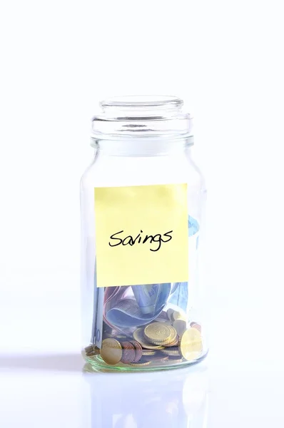 Tarro de vidrio con monedas para ahorrar . — Foto de Stock