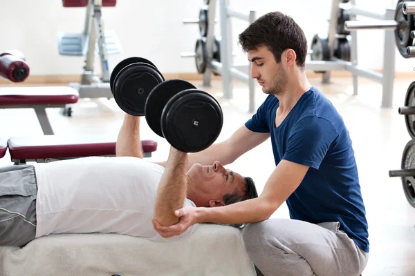 Jeune homme et son père dans la salle de gym — Photo