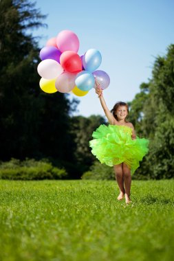 Ñhild with a bunch of balloons in their hands