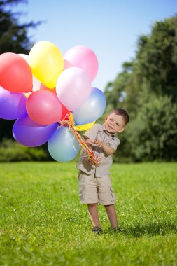 Ñhild with a bunch of balloons in their hands