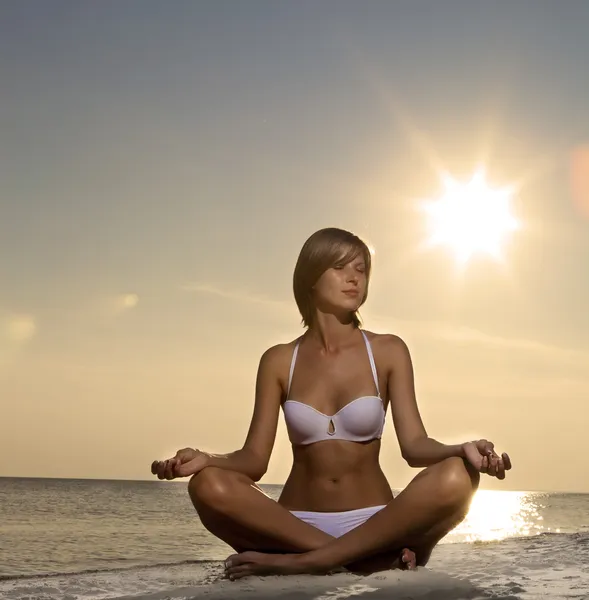 Vacker flicka yoga på stranden vid solnedgången — Stockfoto