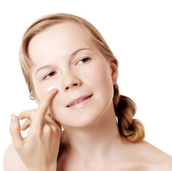 Girl puts on skin cream — Stock Photo, Image