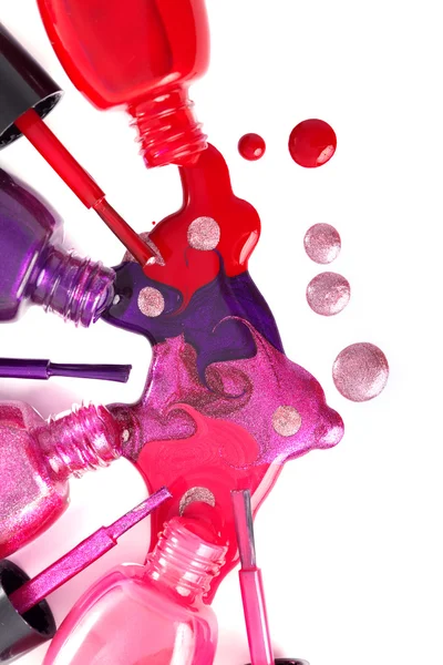 Verniz de unhas coradas derramando de garrafas — Fotografia de Stock