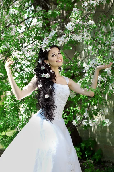 Mooie bruid in een bloeiende tuin — Stockfoto