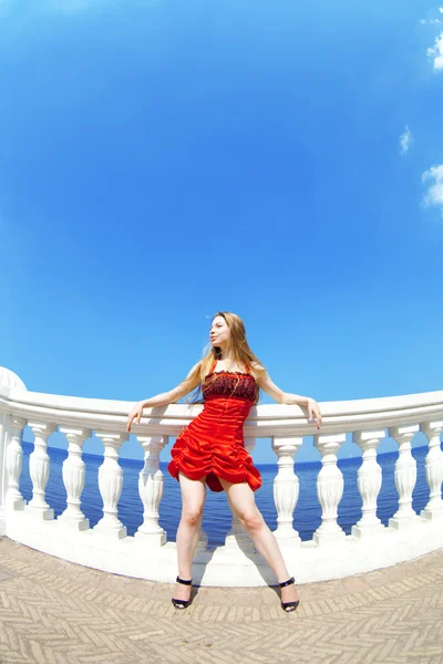 Flicka i röd klänning på stranden — Stockfoto