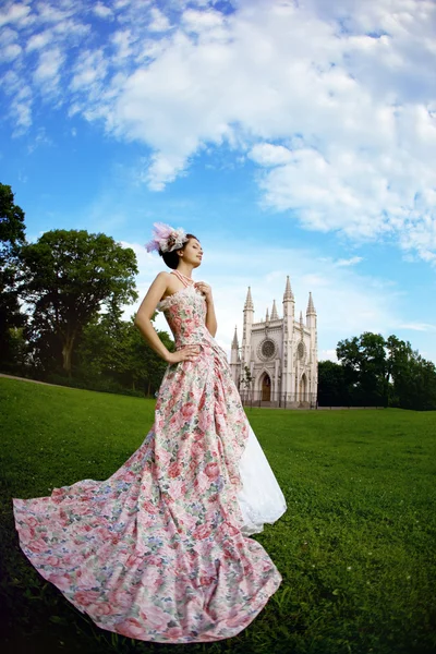 Принцеса в вінтажній сукні перед магічним замком — стокове фото