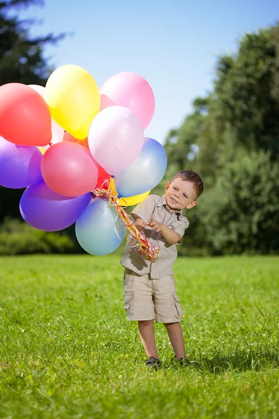 Ñhild with a bunch of balloons in their hands — Stockfoto