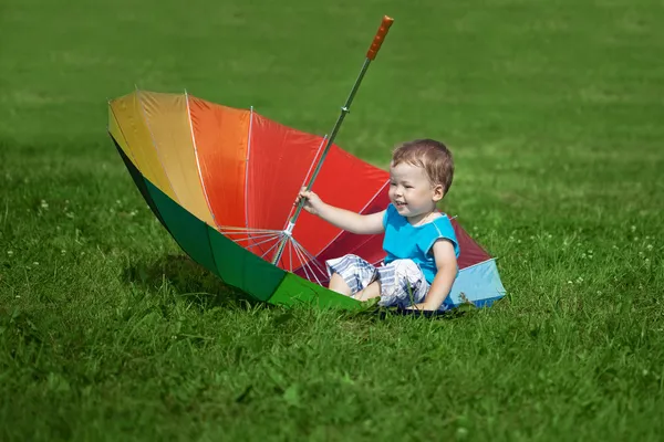 Little boy with a big rainbow umbrella — Stock Photo, Image