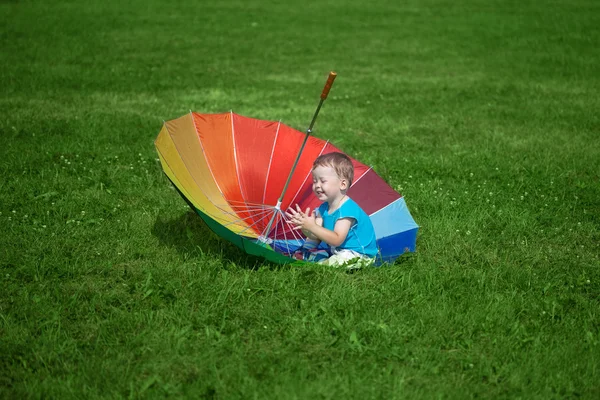 Menino com um grande guarda-chuva arco-íris — Fotografia de Stock