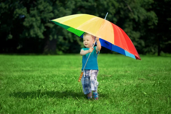 Μικρό αγόρι με ένα μεγάλο ουράνιο τόξο ομπρέλα — Φωτογραφία Αρχείου
