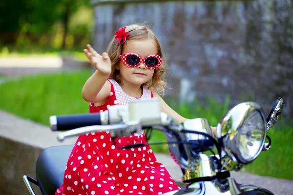 Mädchen im roten Kleid auf einem Motorrad — Stockfoto