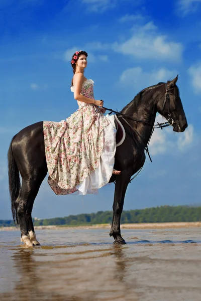 Mulher em um cavalo junto ao mar — Fotografia de Stock
