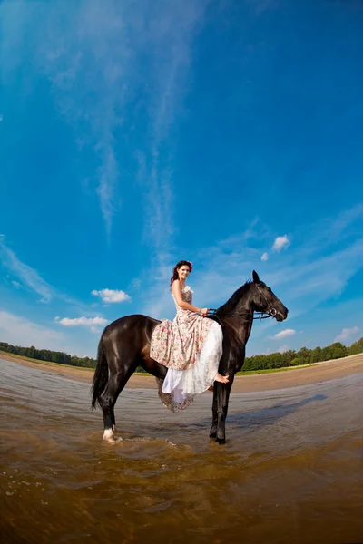 Woman on a horse by the sea — Stock Photo, Image