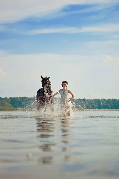 Kvinna på en häst vid havet — Stockfoto