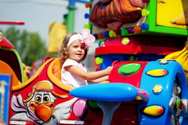 Girl riding on a carousel — Stock Photo, Image