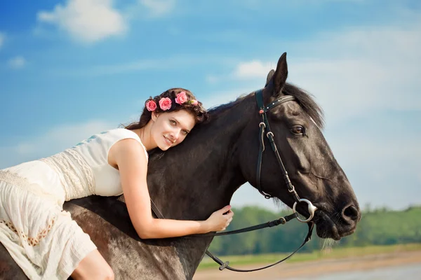 Vrouw op een paard door de zee — Stockfoto