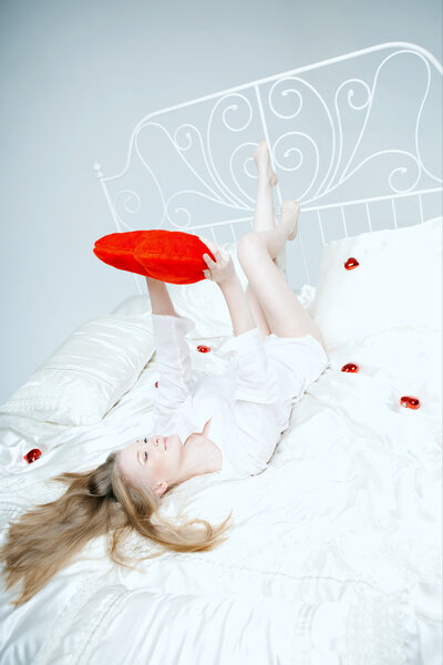 Girl lying on the bed with a red heart