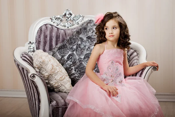 Çocuk üzerinde güzel bir elbise bir sandalyede — Stok fotoğraf