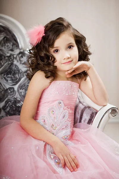 Kind auf einem Stuhl in einem schönen Kleid — Stockfoto