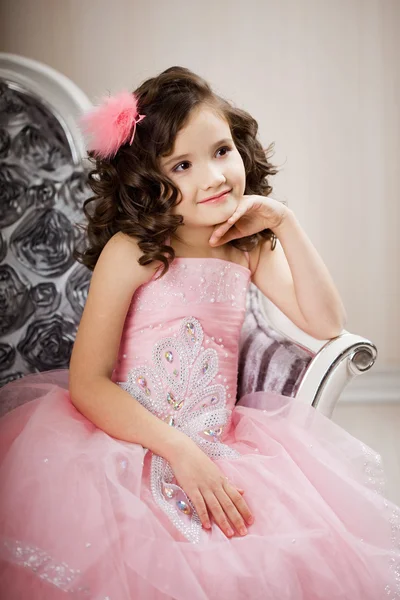 Çocuk üzerinde güzel bir elbise bir sandalyede — Stok fotoğraf