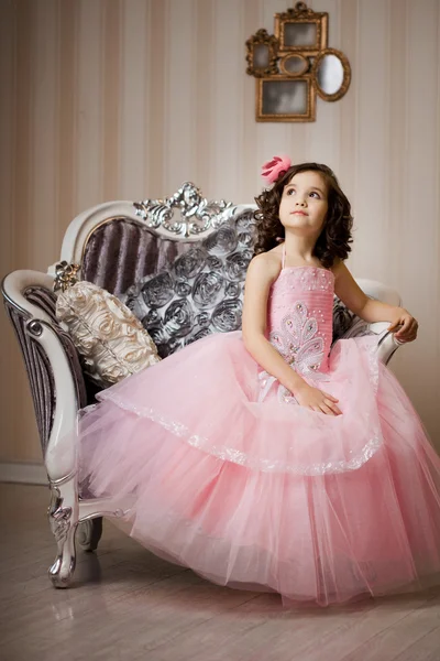 Barnet på en stol i en fin klänning — Stockfoto